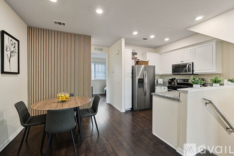 A modern kitchen with a dining table and chairs.