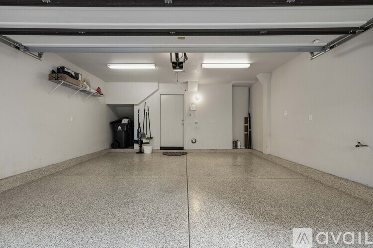 A spacious garage with a concrete floor and white walls.