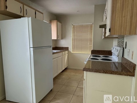 A kitchen with a white refrigerator and a brown countertop.