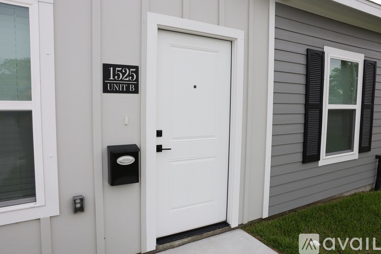 A white door with a black mailbox is on the side of a house.