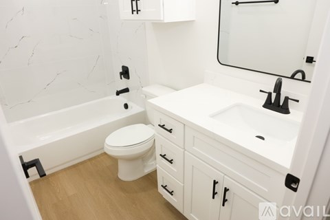 A white bathroom with a marble wall and a white toilet.