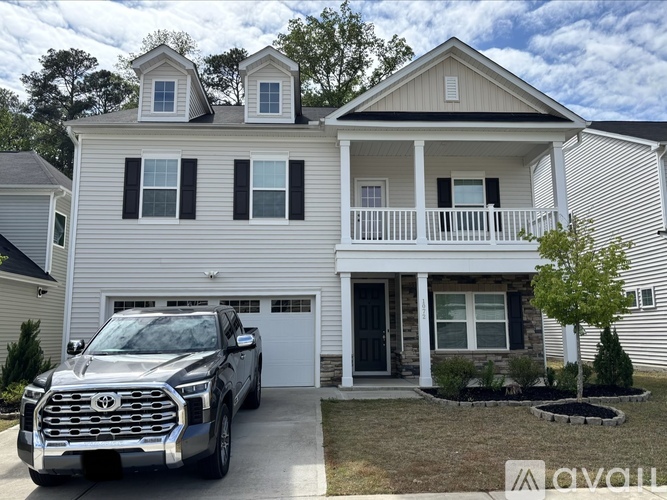 A Toyota truck is parked in front of a two-story house.