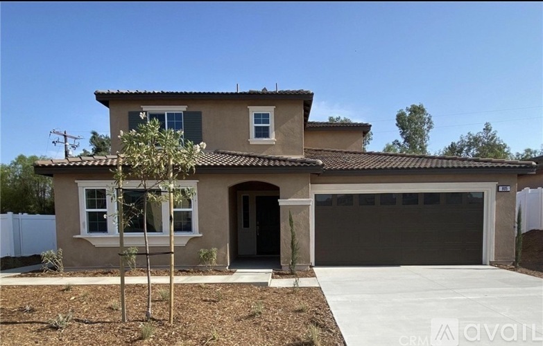 A house with a brown roof and a white fence.