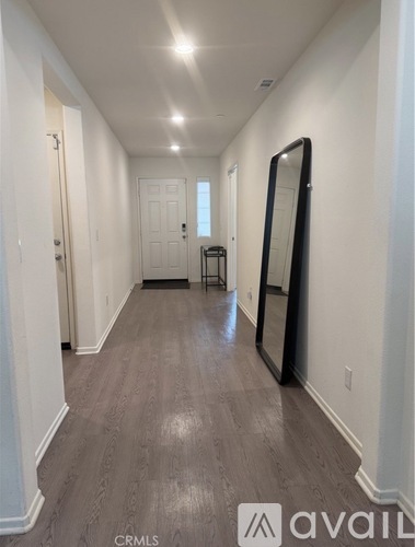 A long hallway with a mirror on the wall.