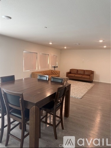 A dining room with a wooden table and chairs.