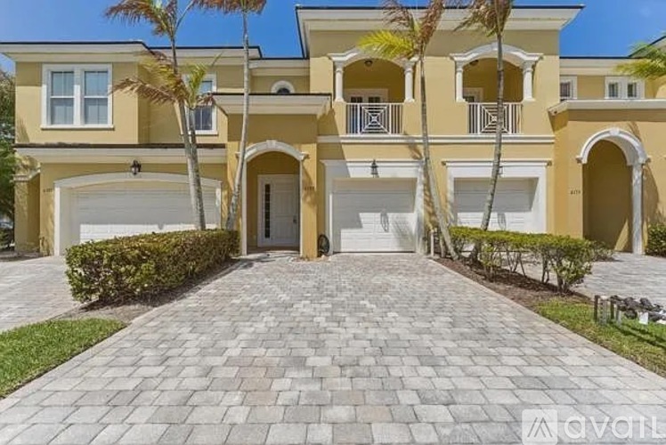 A large, two-story house with a driveway in front.