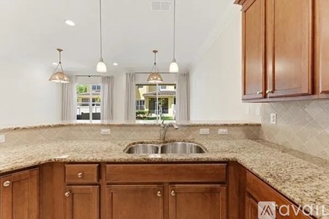 A kitchen with wooden cabinets and a granite countertop.