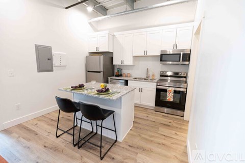 A kitchen with a table and chairs in front of it.