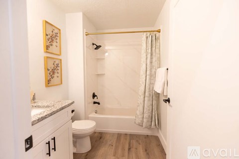 A bathroom with a toilet, sink, and bathtub.
