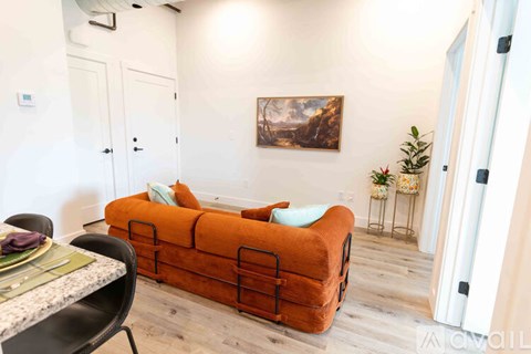 A living room with a sofa, a table, and a painting on the wall.