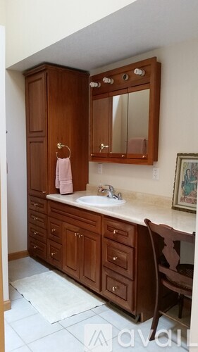 A brown wooden vanity with a sink and mirror.