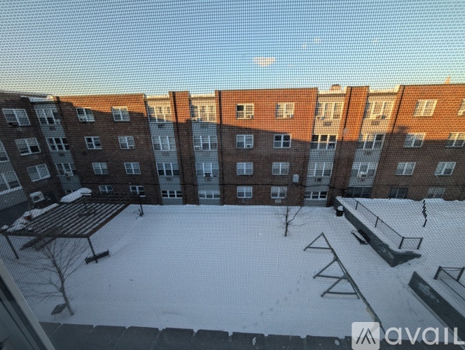 A snow-covered courtyard in front of a brick apartment building.