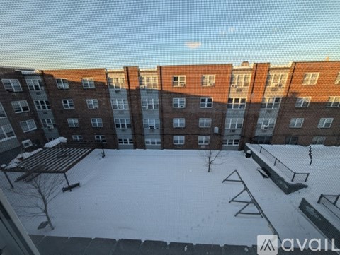 A snow-covered courtyard in front of a brick apartment building.