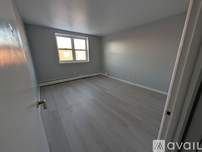 A room with a window and wooden flooring.