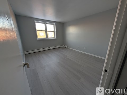A room with a window and wooden flooring.