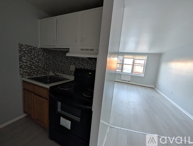 A kitchen with a black oven and a window letting in light.