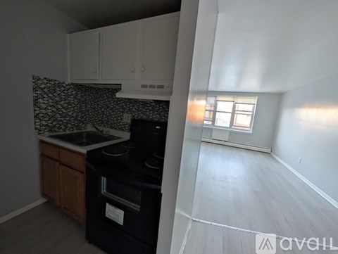 A kitchen with a black oven and a window letting in light.