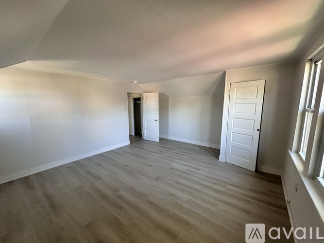A room with a ceiling fan and three windows.