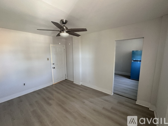 A room with a ceiling fan and two doors.