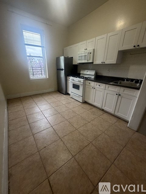 A kitchen with white cabinets and appliances.