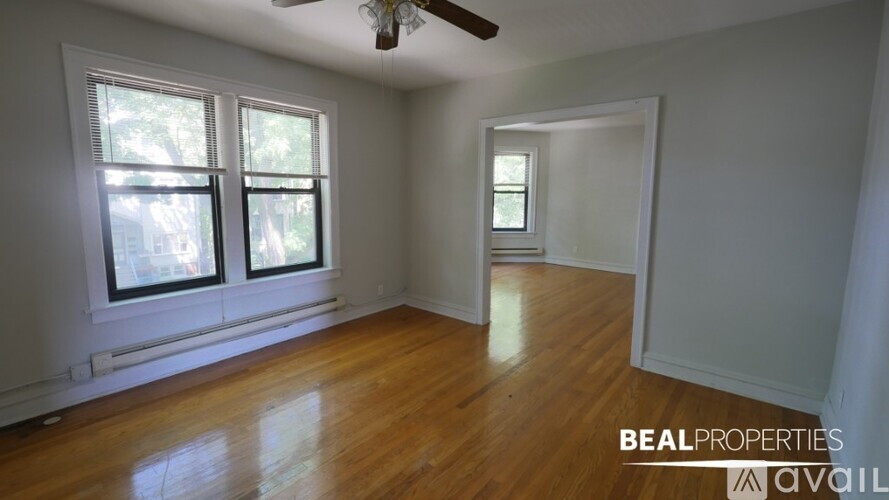 A room with a ceiling fan and wooden flooring.