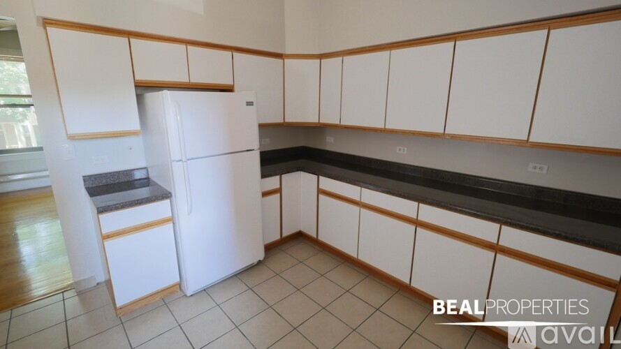 A kitchen with white cabinets and a white fridge.