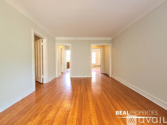 A long hallway with wooden floors and white walls.
