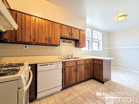A kitchen with a white stove and a white dishwasher.