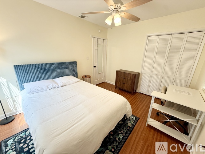 A bedroom with a large bed and a ceiling fan.