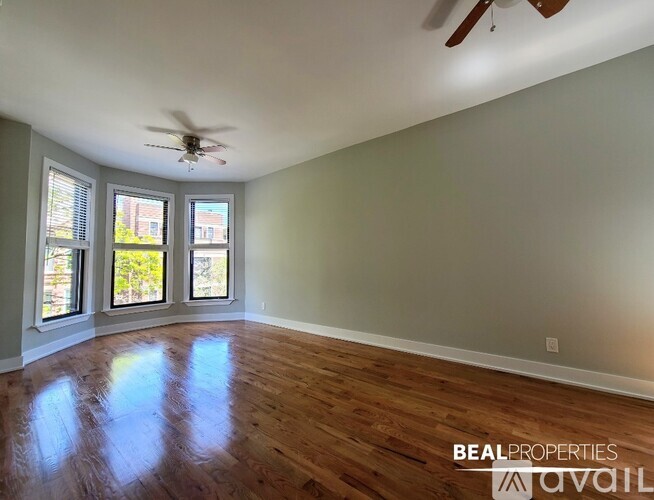 A room with a ceiling fan and wooden flooring.