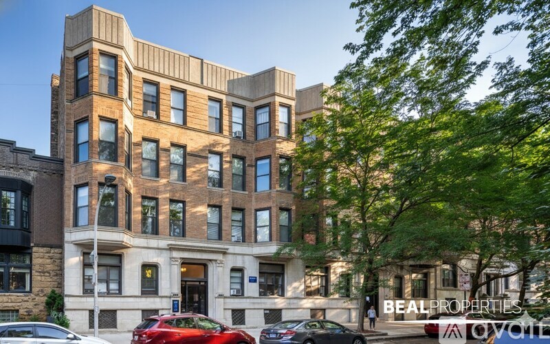 A multi-story building with a parking lot in front of it.