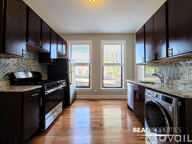 A kitchen with dark wood cabinets and granite countertops.