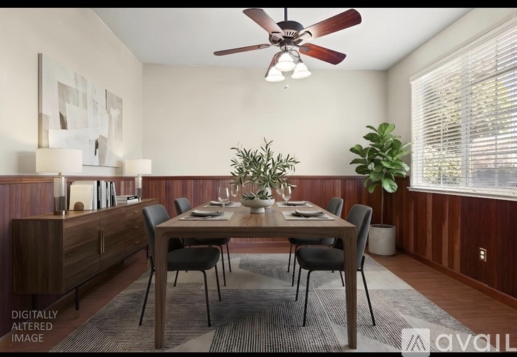 A dining room with a wooden table and chairs.