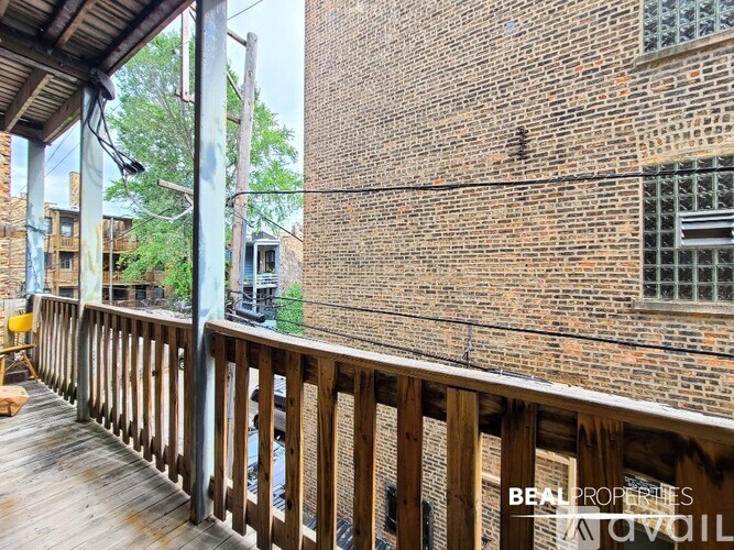 A wooden deck with a brick building in the background.