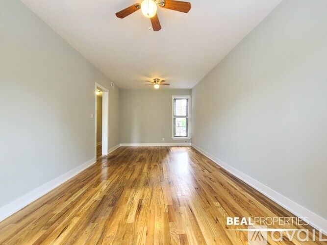 A room with wooden floors and a ceiling fan.