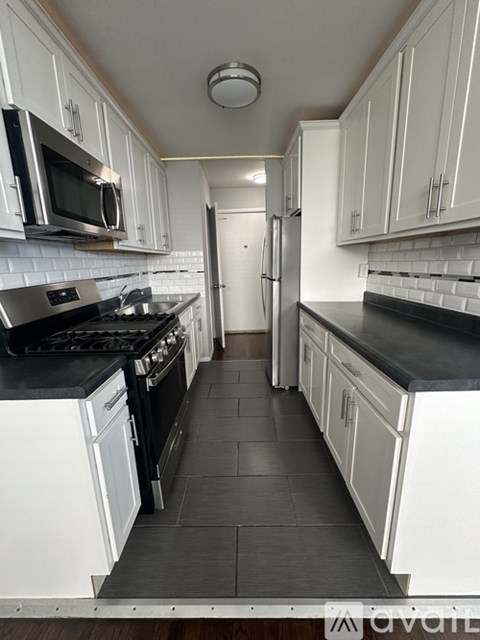 A kitchen with black countertops and white cabinets.
