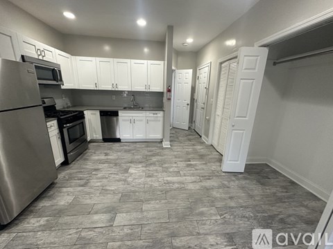 A kitchen with a refrigerator, oven, and sink.