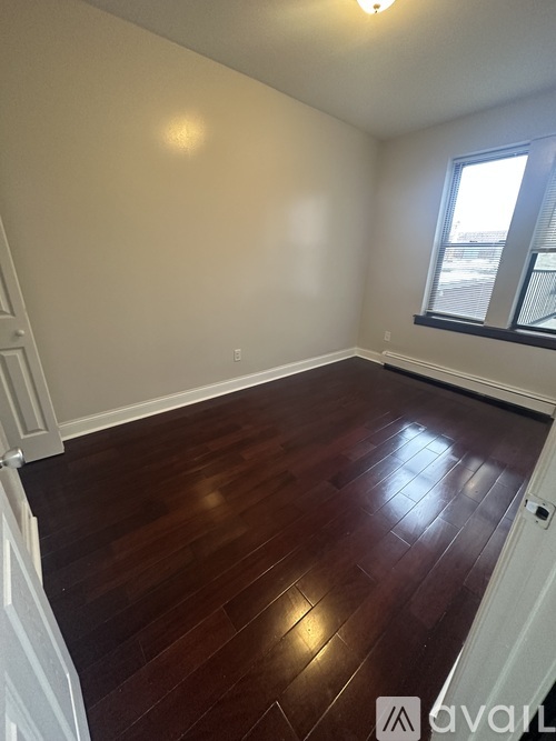 A room with wooden flooring and a window.