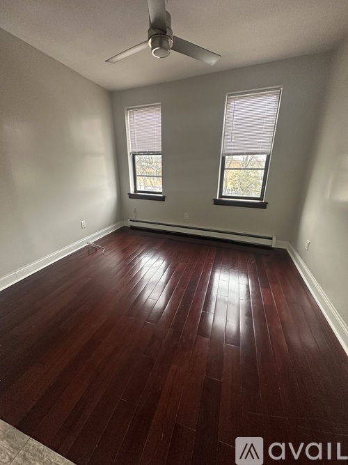 A room with a wooden floor and a ceiling fan.