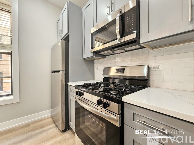 A modern kitchen with a stove, refrigerator, and microwave.