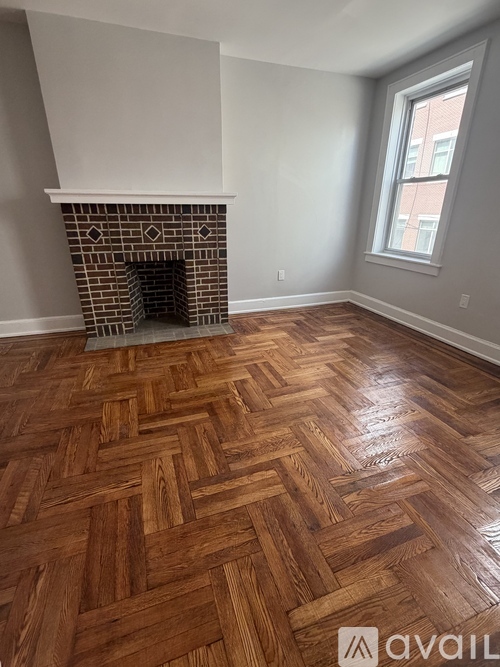 A room with a fireplace and wooden flooring.
