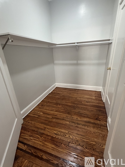 A hallway with wood flooring and white walls.