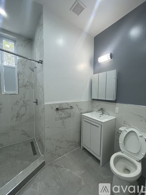 A bathroom with a toilet, sink, and shower.