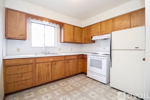 A kitchen with wooden cabinets and a white refrigerator.