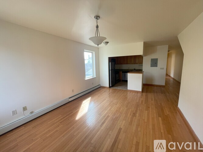 A room with wooden flooring and a large window.