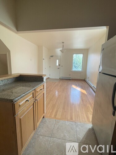 A kitchen with wooden cabinets and a refrigerator.