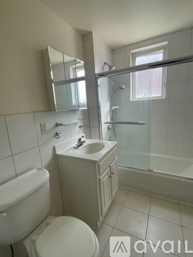 A white bathroom with a toilet, sink, and bathtub.