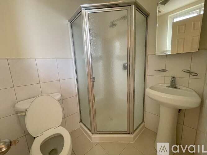 A white toilet sits next to a sink in a bathroom.