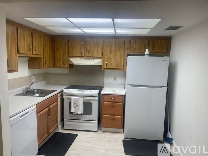 A kitchen with wooden cabinets and white appliances.