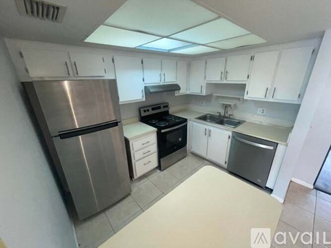 A kitchen with a stainless steel refrigerator, oven, and sink.